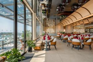 a restaurant with tables and chairs and large windows at The IRIS SIGNATURE HOTEL AND SPA in Can Tho