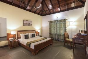 a bedroom with a bed and a table and a desk at Club Mahindra Cherai Beach, Kochi in Cherai Beach +58 photos