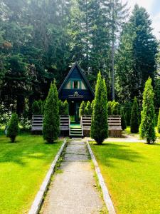 a blue house in the middle of a yard with trees at Chalet Musala in Borovets
