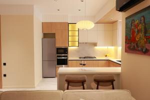 a kitchen with a counter and some chairs in it at PANA Apartments in Nukus +7 photos