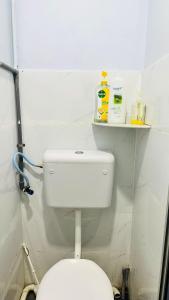 a bathroom with a white toilet and a shelf at Bidara Guest House in Kampong Sungai Baru Tengah