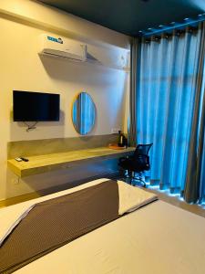 a bedroom with a bed and a tv and a chair at Trident Sea Hotel in Negombo
