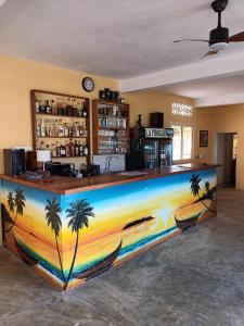 a bar with palm trees painted on it in a room at Hôtel-bungalows La Pirogue in Sambava