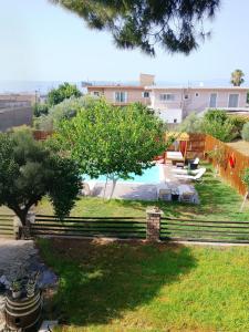 a backyard with a pool and trees and a building at Alice house 3 in Amarynthos