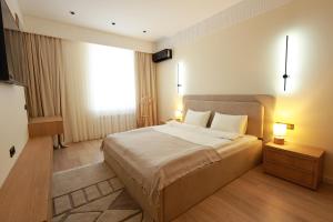 a bedroom with a large bed and a window at PANA Apartments in Nukus