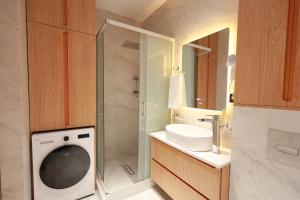 a bathroom with a washing machine and a sink at PANA Apartments in Nukus