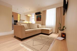 a living room with a couch and a kitchen at PANA Apartments in Nukus