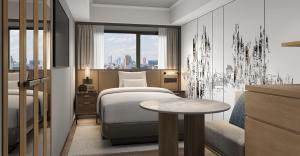 a bedroom with a bed and a table and a window at Hotel Pearl City Kobe in Kobe