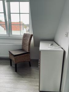 a room with a chair and a table and window at Gästehaus St Markus in Höxter