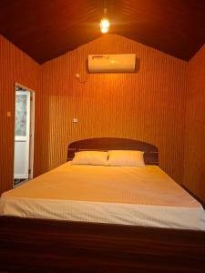 a bedroom with a bed in a wooden wall at Chill Hutz in Vedakudiyiruppu