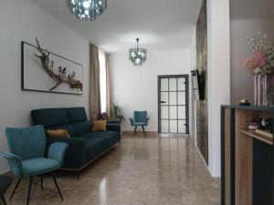 a living room with a blue couch and chairs at Hollywood rooms in Sveti Petar