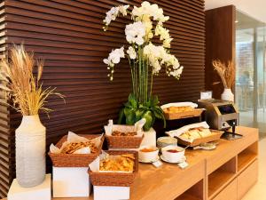 a table with baskets of food and a vase of flowers at Jazzotel Bangkok in Bangkok