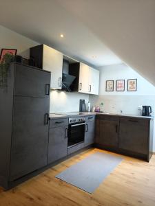 a kitchen with stainless steel appliances and wooden floors at Ferienwohnung Im Distelweg in Scheid