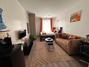 a living room with a couch and a bed at Homes by Sil Bn in Muchatha