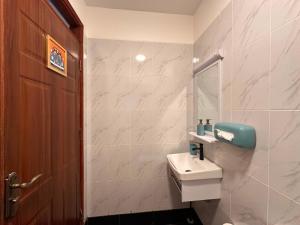 a white bathroom with a sink and a mirror at Homes by Sil Bn in Muchatha