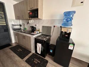 a small kitchen with a stove and a refrigerator at Homes by Sil Bn in Muchatha