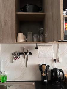 a kitchen counter with utensils on a shelf at Homes by Sil Bn in Muchatha