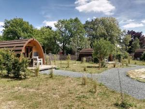 a small cabin in a garden with a gravel yard at Camping le Rochat Belle Isle in Châteauroux
