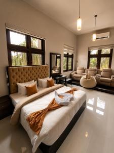 a large bedroom with a large bed and a couch at Dhanora Dynasty Resort in Anuradhapura +6 photos