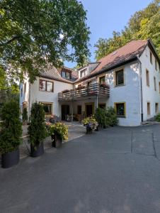 a large white building with trees and plants at Hotel Pension Blüchersruh in Bad Berneck im Fichtelgebirge