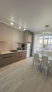 a kitchen and dining room with a table and chairs at Алпамыс - В пешей доступности Центральный парк, ЦУМ, ТРЦ MART in Kostanay