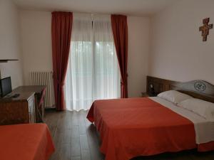 a bedroom with a bed and a window with red curtains at Hotel Terme in Tempone