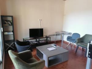 a living room with chairs and a table and a tv at Camping le Rochat Belle Isle in Châteauroux