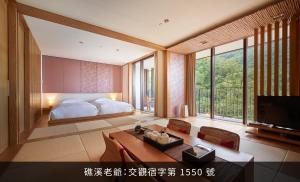 a bedroom with a bed and a table and chairs at Hotel Royal Chiao Hsi in Jiaoxi