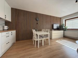 a kitchen with a table and chairs in a room at Piast Castle Apartment Brzeg in Brzeg +11 photos