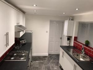 a kitchen with a sink and a stove top oven at JO Wordsworth Apartment in Hull