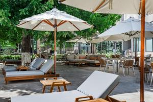 a patio with couches and umbrellas and tables at Radisson Blu Hotel, Tashkent in Tashkent