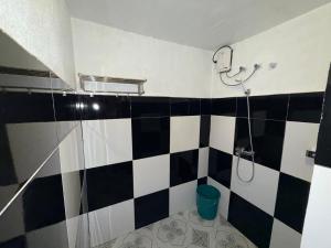 a bathroom with a black and white checkered wall at Kwarto's in Siquijor