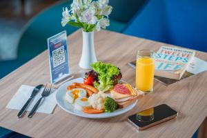 a table with a plate of food and a glass of orange juice at Holiday Inn Express - Yerevan by IHG in Yerevan