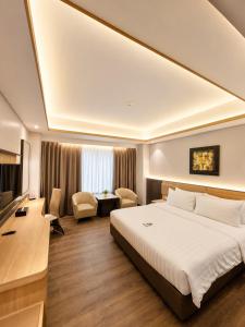 a hotel room with a large bed and a television at Orchardz Hotel Industri Jakarta Kemayoran in Jakarta +68 photos