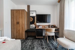 a hotel room with a desk and a tv at Malinowy Potok in Białka Tatrzańska