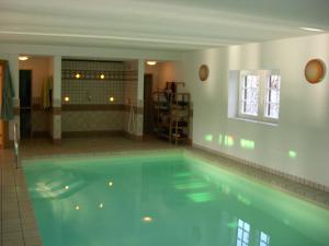 a large swimming pool in a room with a bathroom at The Cosy Home in Hodenhagen