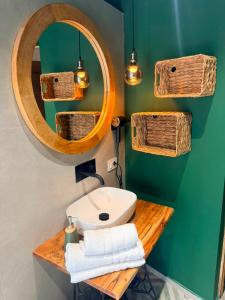 a bathroom with a sink and a mirror and wicker baskets at Le Tartarughe - Rooms and Apartments - in Milazzo +80 photos