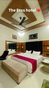 a hotel room with two beds and a heart on the wall at The Eros in Sonīpat