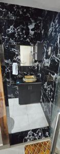 a bathroom with a black marble wall at The Eros in Sonīpat