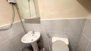 a bathroom with a sink and a toilet and a mirror at 1403-304 Saekyung Pool view in Lapu Lapu City +13 photos