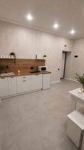 a large kitchen with white cabinets and a sink at Алпамыс - В пешей доступности Центральный парк, ЦУМ, ТРЦ MART in Kostanay
