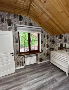 an empty room with a window and a wooden ceiling at Yusubovs in Hacıkǝnd
