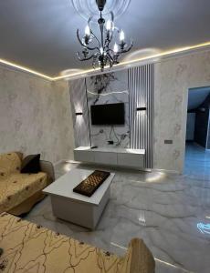 a living room with a couch and a chandelier at Yusubovs in Hacıkǝnd