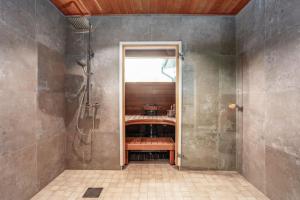 a bathroom with a shower with a sink and a shower at Villa Syreeni - Seafront/Jacuzzi in Kilpilahti