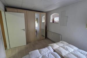 a bedroom with a bed with white sheets and a mirror at NEU! Ferienwohnung am Schanzenbach in Hartha +6 photos