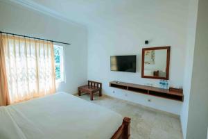 ein Schlafzimmer mit einem Bett, einem Waschbecken und einem Spiegel in der Unterkunft Sari Bunga Hotel - Legian, walking distance to Legian Beach in Legian