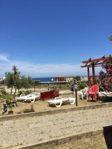 a group of chairs and tables on the beach at Villa DonnAnna in Cariati
