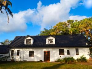 a white house with a black roof at The Meadow Manor in Port Edward