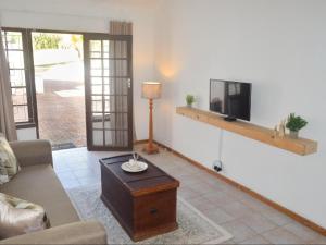 a living room with a couch and a tv at The Meadow Manor in Port Edward