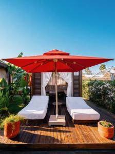 a patio with two beds and a red umbrella at Adalya Elite Lara Hotel - Ultra All Inclusive in Lara